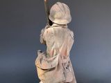 statue of a woman with a sword and a bowl of soup