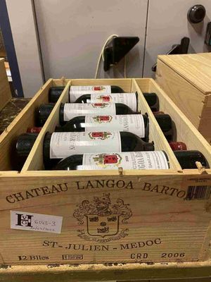 plusieurs bouteilles de vin se trouvent dans un coffret en bois sur une table