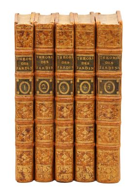 six vieux livres sont alignés sur une surface blanche