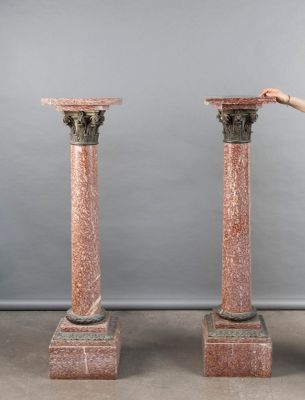 a woman that is standing next to a pair of pillars