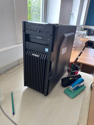 a computer on a table with a pen and a bottle of water