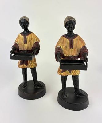 pair of african figurines of a woman holding trays of food