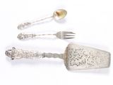 three silver spoons and a fork on a white surface