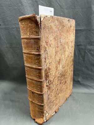 an old book sitting on top of a table with a piece of paper sticking out of it