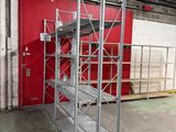 a room with a red wall and a metal shelf