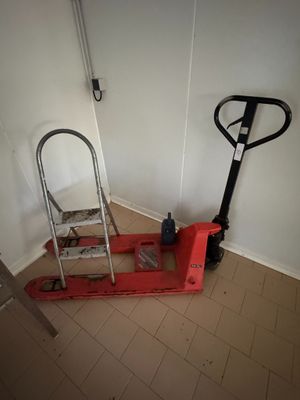 une photo montrant un chariot élévateur et une échelle dans un coin d'une pièce