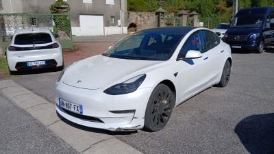 une Tesla blanche garée sur le bord de la route
