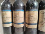 four bottles of wine are lined up on a table