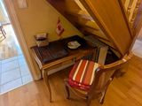 a desk with a chair underneath a set of stairs