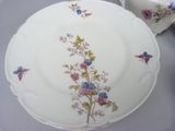 a plate with flowers and birds on it on a table