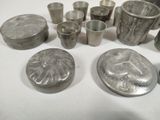 a lot of silver cups and pans sitting on a table