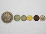 a row of five different coins sitting on top of a white surface