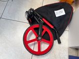 a red wheel on the floor next to a black bag