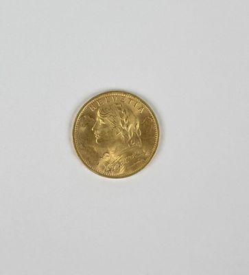 gros plan d'une pièce d'or sur une surface blanche