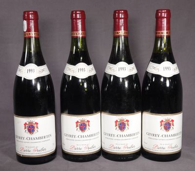 quatre bouteilles de vin sont alignées sur une table