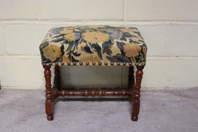 un petit banc en bois avec une assise rembourrée à motifs floraux