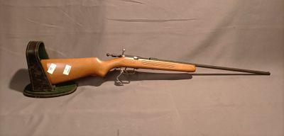 un vieux fusil avec une poignée en bois sur un fond gris