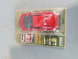 a red toy car in a package on a table