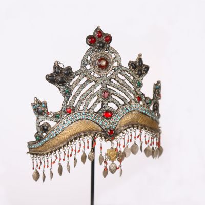 a silver crown with red and green jewels on it