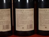three bottles of wine are lined up on a table