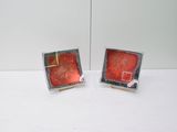 pair of red and silver square cufflinks on a white surface