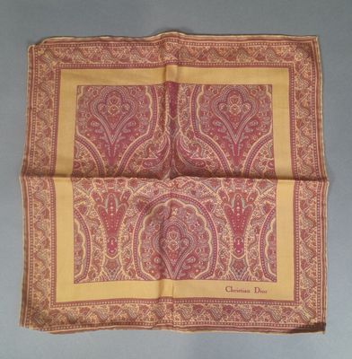 a close up of a pink and yellow paisley print handkerchief