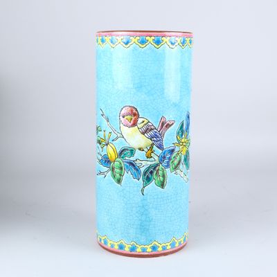 un vase bleu sur lequel est peint un oiseau sur le côté