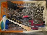 un panier rempli d'ustensiles de cuisine et une cuillère en bois