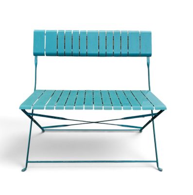 un banc bleu posé sur un sol blanc, près d'un mur blanc