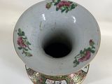 a white vase with pink flowers on it on a white surface
