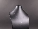 collier posé sur un support pour mannequin, sur fond noir