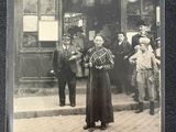 une vieille photo d'une femme debout devant une gare