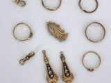 an image of a collection of gold rings and rings on a white surface