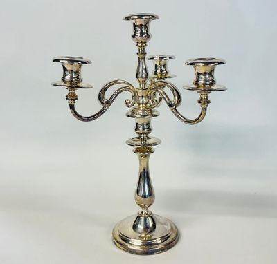 a silver candelier with three candles on a white background