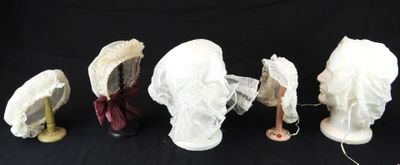 quatre chapeaux sont alignés sur un fond noir