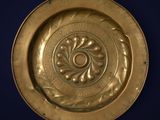brass plate with a circular design on a blue background