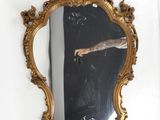 a mirror hanging on the wall with a person taking a picture of it