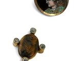 three pieces of jewelry including a broochi and a pin with a lady ' s face