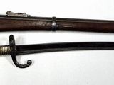 pair of old guns hanging on a hook on a wall