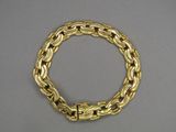a close up of a gold bracelet on a gray surface