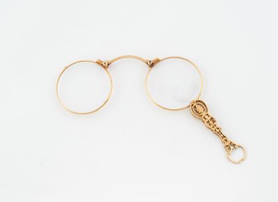 une paire de lunettes plaquées or avec une chaîne, sur fond blanc
