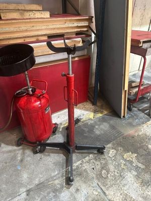 un extincteur rouge posé à côté d'une pile de bois