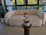 a white couch sitting in front of a window next to a table