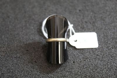 une bague à laquelle est accrochée une étiquette, posée sur une table