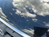a reflection of a person in the hood of a car
