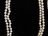 a white pearl necklace and earring set with a gold clasp