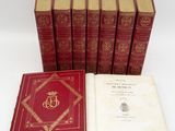 six red books sitting on top of each other on a white surface