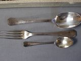 three spoons and two forks sitting on a table
