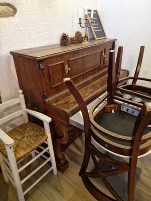 une table avec des chaises et un piano dans une pièce