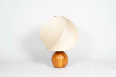 une lampe dotée d'un pied en bois et d'un abat-jour blanc
